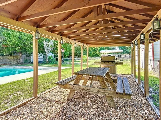 a view of house with swimming pool and a yard