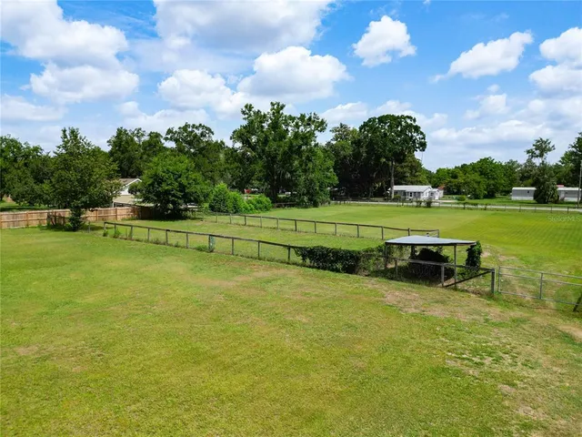 a view of a dining room with furniture a kitchen and chandelier