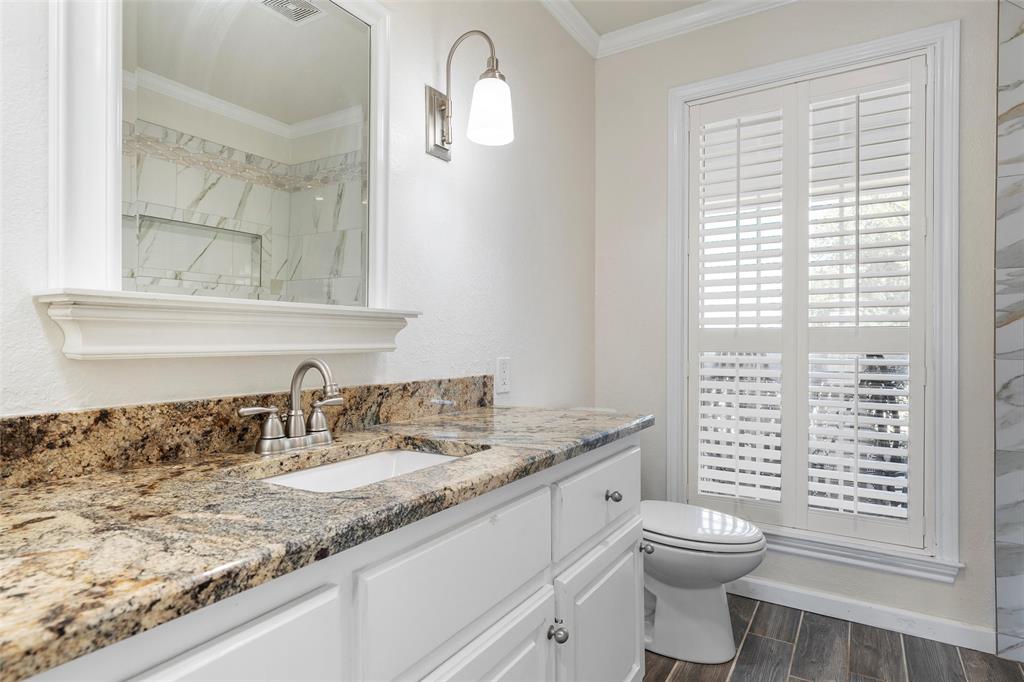 5112 Old Caufield Ranch Road McGregor, TX 76657 - Photo 28 of 38 Bathroom featuring crown molding, wood finish floors, vanity, and a shower