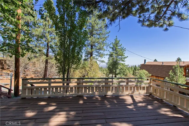 a view of a balcony with wooden floor and fence