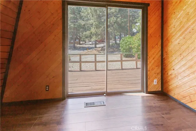 a view of a small space with wooden floor and a window