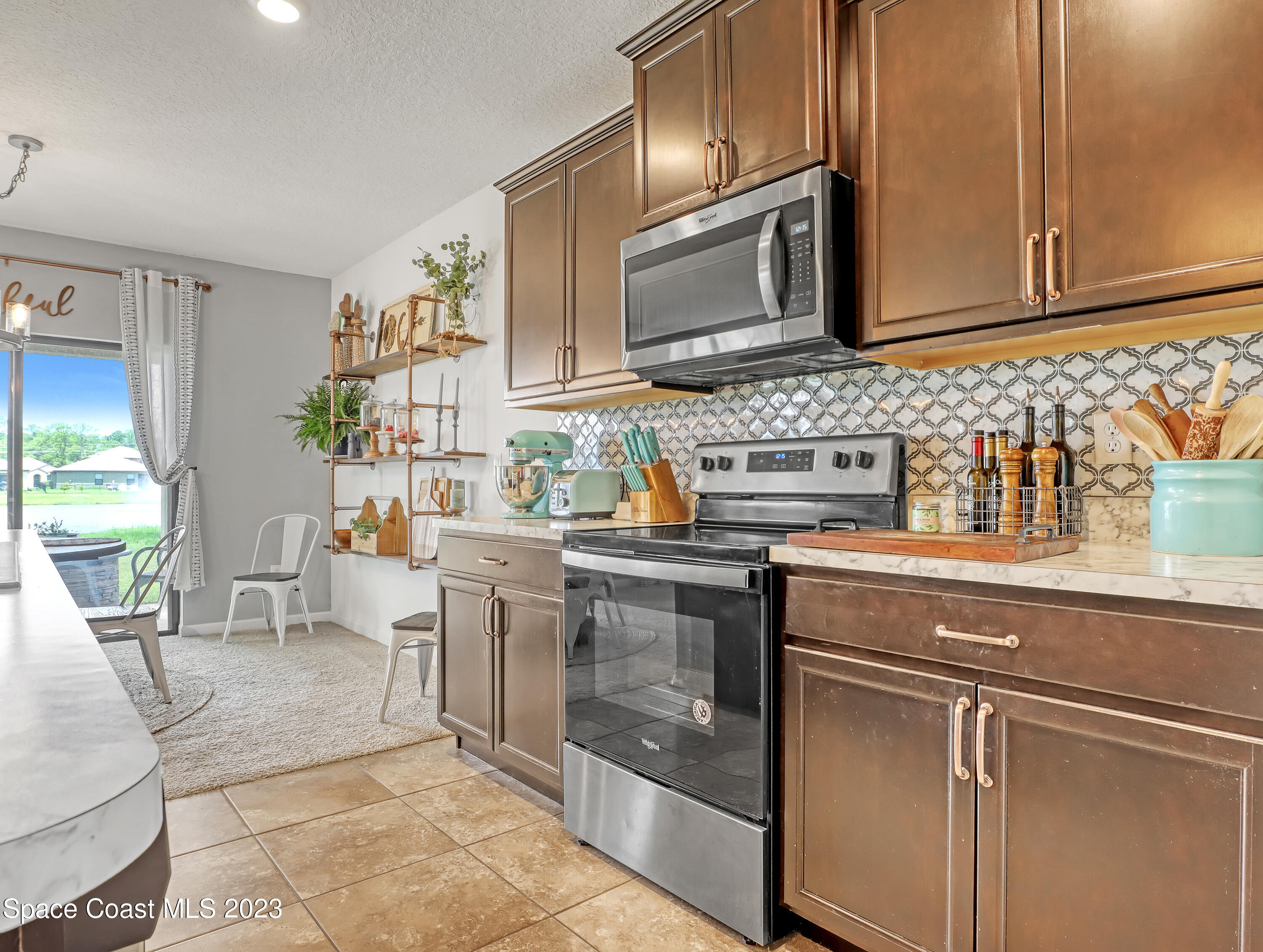 1652 Saxton Road Cocoa, FL 32926 - Photo 14 of 53 a kitchen with stainless steel appliances granite countertop a sink stove and microwave