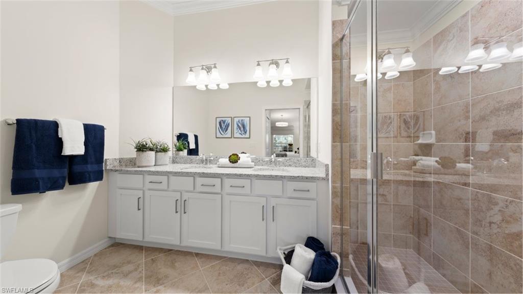 5466 Double Eagle Circle, Unit 3423 Ave Maria, FL 34142 - Photo 16 of 24 Bathroom with crown molding, vanity, an enclosed shower, and toilet