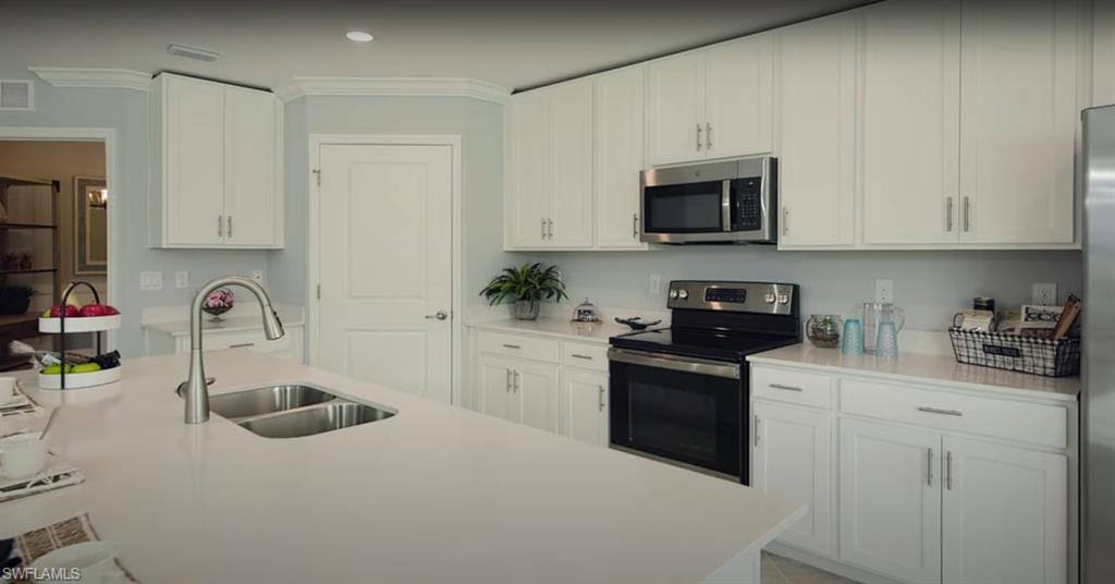 5466 Double Eagle Circle, Unit 3423 Ave Maria, FL 34142 - Photo 2 of 24 Kitchen with stainless steel appliances, white cabinetry, and sink