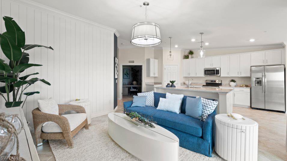 5466 Double Eagle Circle, Unit 3423 Ave Maria, FL 34142 - Photo 7 of 24 Living room featuring ornamental molding, sink, light tile patterned floors, and wooden walls