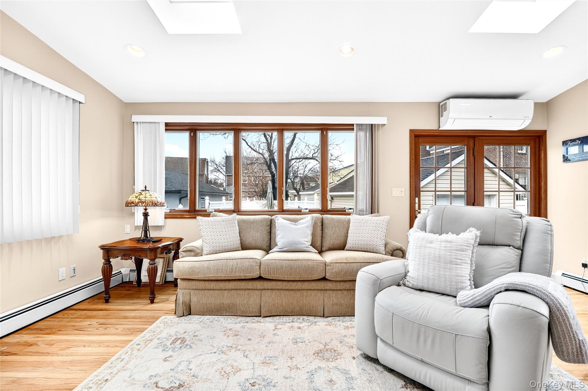 3334 Country Club Road Bronx, NY 10465 - Photo 24 of 49 Living room featuring a skylight, light wood-style floors, a wall mounted AC, and recessed lighting