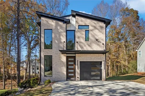 a front view of a house with a tree