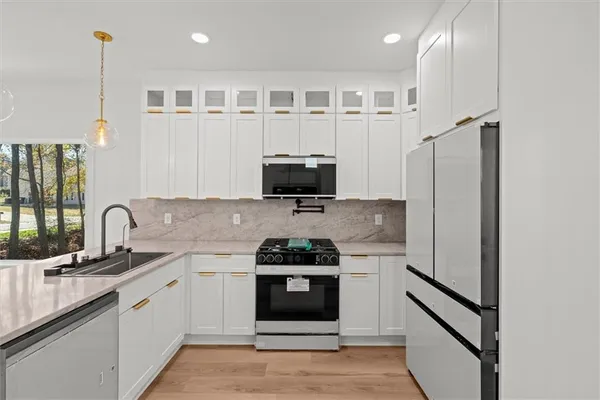 a kitchen with stainless steel appliances a stove a sink and a microwave