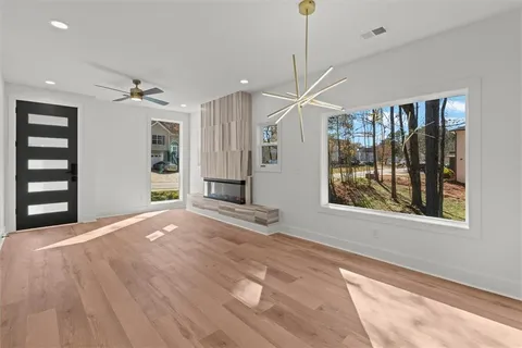 a view of an empty room with a window and a kitchen