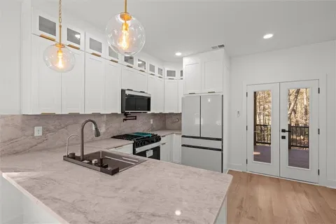 a kitchen with a sink and a stove top oven with wooden floor
