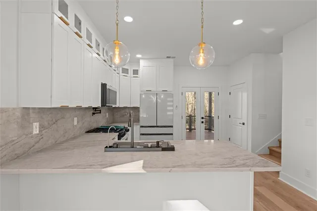 a kitchen with stainless steel appliances a stove a sink and a microwave