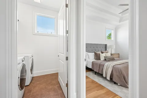 a bedroom with a bed and a potted plant on the dresser