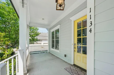 a view of porch with a floor to ceiling window and wooden fence
