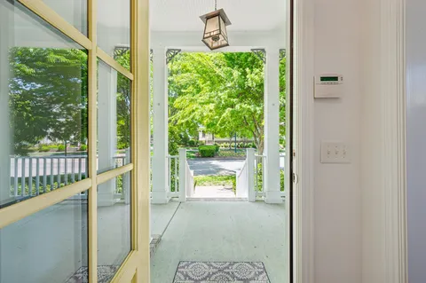 a view of a hallway with wooden floor and furniture