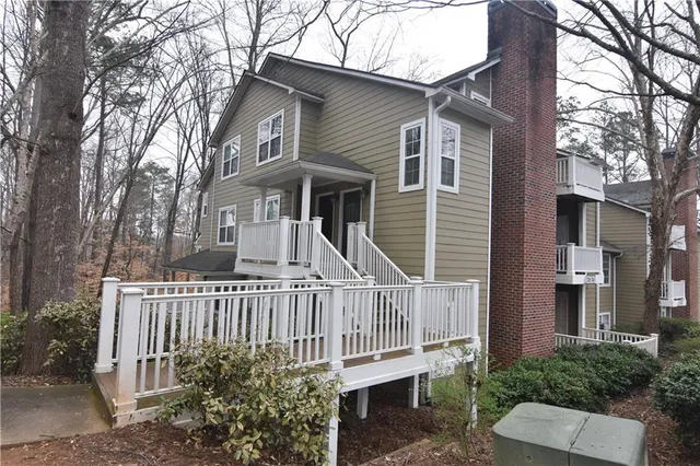 a view of a house with a small yard and wooden fence