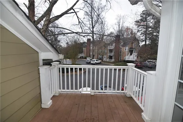 a view of a balcony with wooden floor and fence