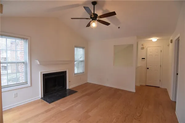 a view of an empty room with a fireplace and a window