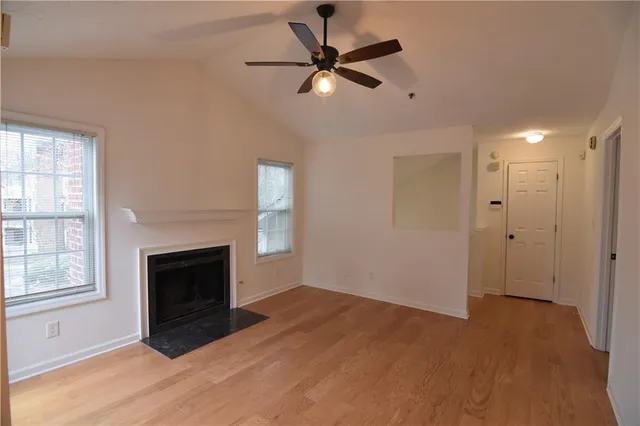 a view of an empty room with a fireplace and a window