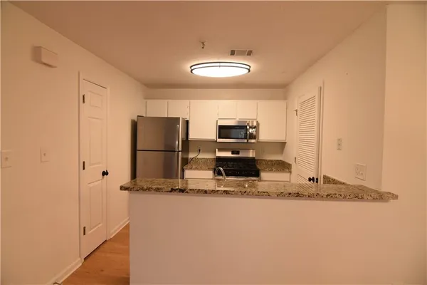 a kitchen with kitchen island granite countertop cabinets and refrigerator