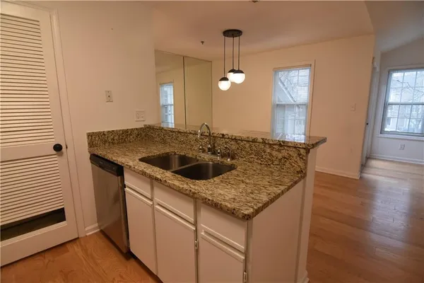 a kitchen with a sink a counter space and wooden floor