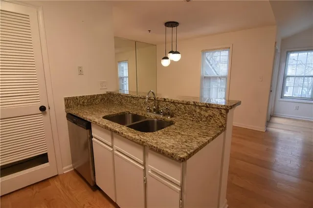 a kitchen with a sink a counter space and wooden floor