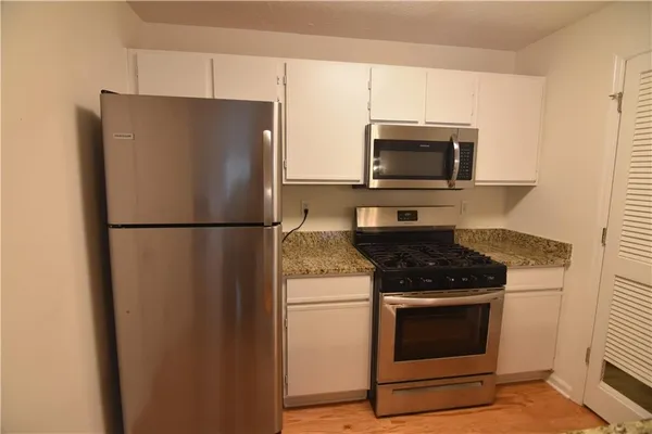 a kitchen with granite countertop cabinets and steel stainless steel appliances