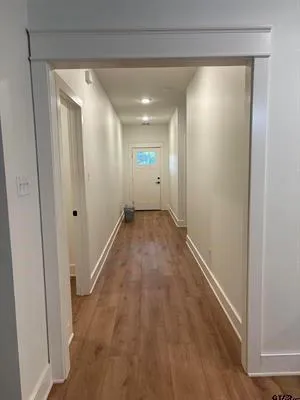 a view of hallway with wooden floor