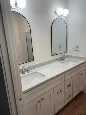 a bathroom with a double vanity sink and a mirror