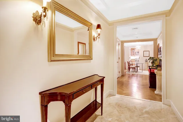 a view of a hallway with wooden floor and a living room