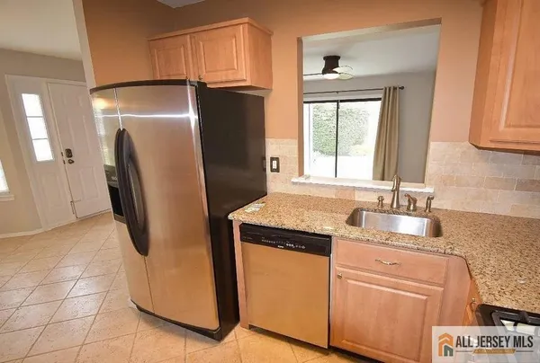 a kitchen with appliances a refrigerator and a sink