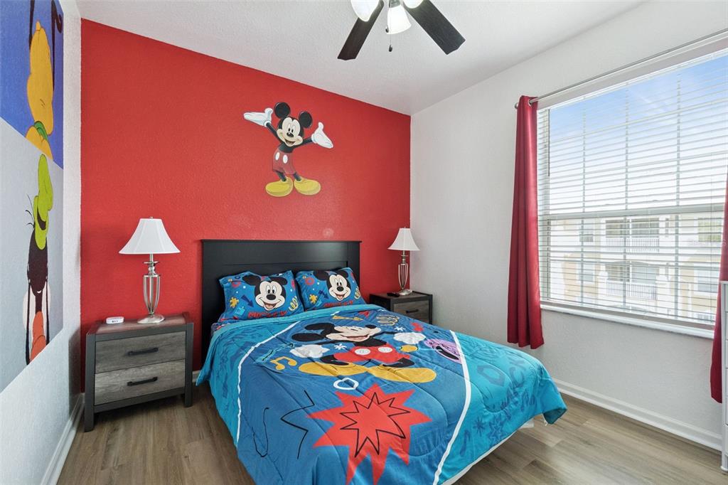 2809 Almaton Loop, Unit 401 Kissimmee, FL 34747 - Photo 16 of 59 a bedroom with a bed and a lamp on dresser with wooden floor