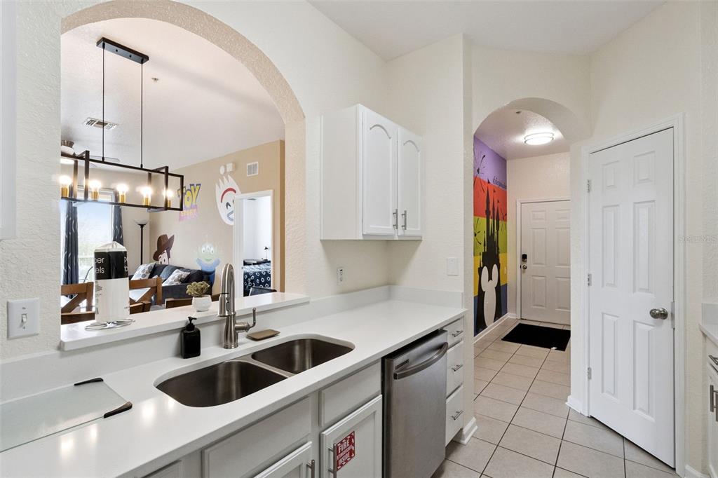 2809 Almaton Loop, Unit 401 Kissimmee, FL 34747 - Photo 9 of 59 a kitchen with stainless steel appliances kitchen island granite countertop a sink a counter space and cabinets