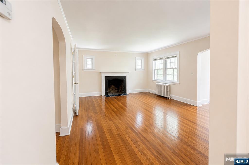 298 Audubon Road Englewood, NJ 07631 - Photo 3 of 19 a view of empty room with wooden floor and fireplace