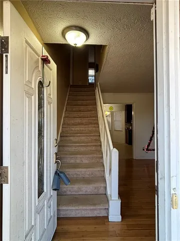 a view of entryway and hall with wooden floor