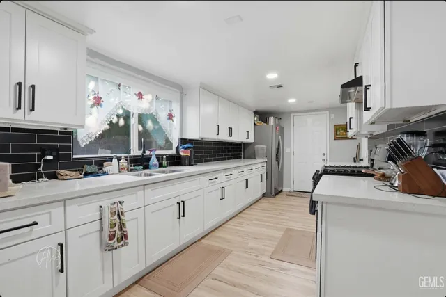 a kitchen with granite countertop white cabinets and white appliances