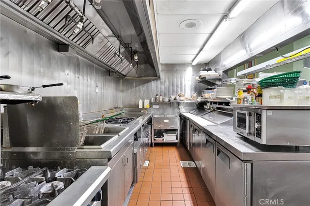 a kitchen with stainless steel appliances granite countertop a sink a stove and a wooden floors