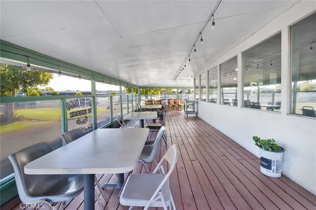a dining room with furniture a potted plant and wooden floor