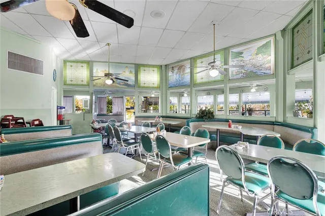 a view of a dining room with furniture large windows and wooden floor