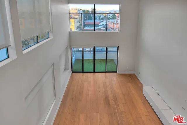 a view of a room with wooden floor and a window
