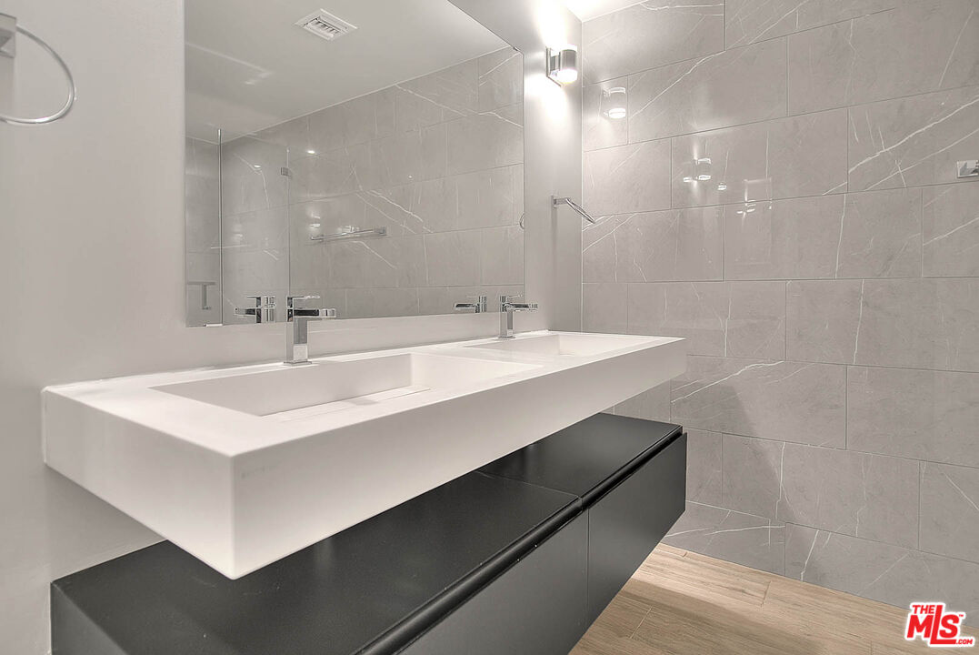 5014 Rosewood Avenue, Unit 1/2 Los Angeles, CA 90004 - Photo 22 of 45 a bathroom with a sink a mirror and a shower