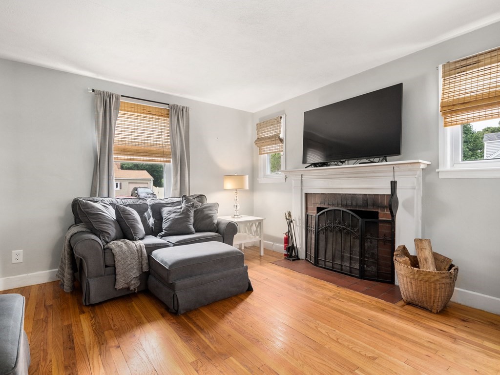 86 Anniversary Street Springfield, MA 01104 - Photo 12 of 31 a living room with furniture a flat screen tv and a fireplace
