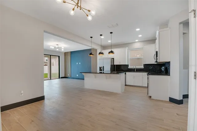 a view of a livingroom with wooden floor and a ceiling fan