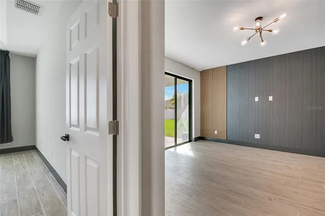 a view of a big room with a chandelier fan and windows