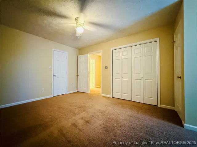 a view of an empty room with a ceiling fan