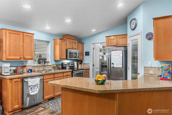a kitchen with stainless steel appliances granite countertop a sink a stove and a refrigerator