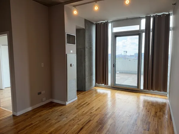 an empty room with wooden floor and a bathroom