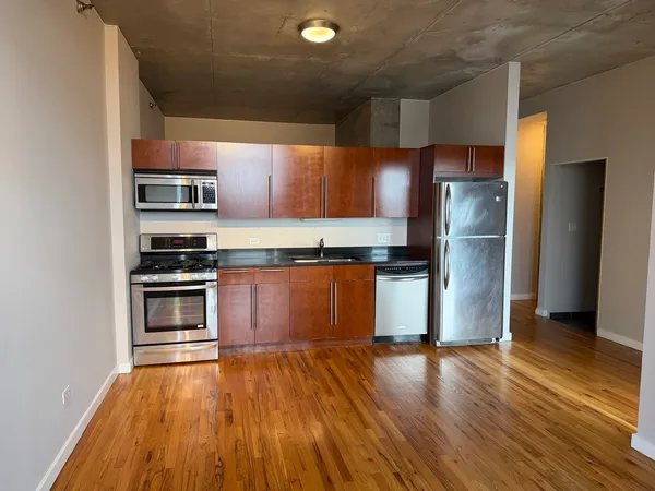 a kitchen with stainless steel appliances granite countertop a refrigerator and a stove top oven