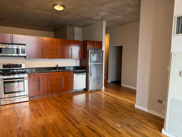 a kitchen with wooden floors and stainless steel appliances