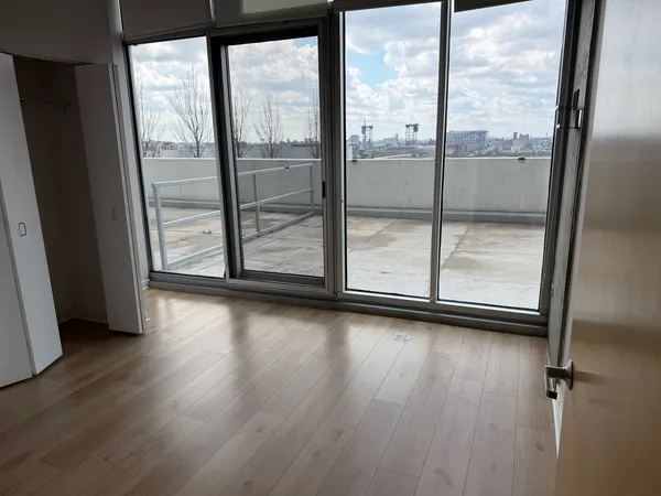 an empty room with wooden floor and door