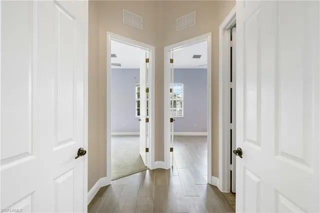 a view of a hallway with wooden floor and front door